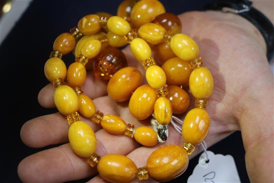 A single strand graduated oval amber bead necklace with spacers and an amber bead bracelet, gross weight 130 grams, necklace 46cm.